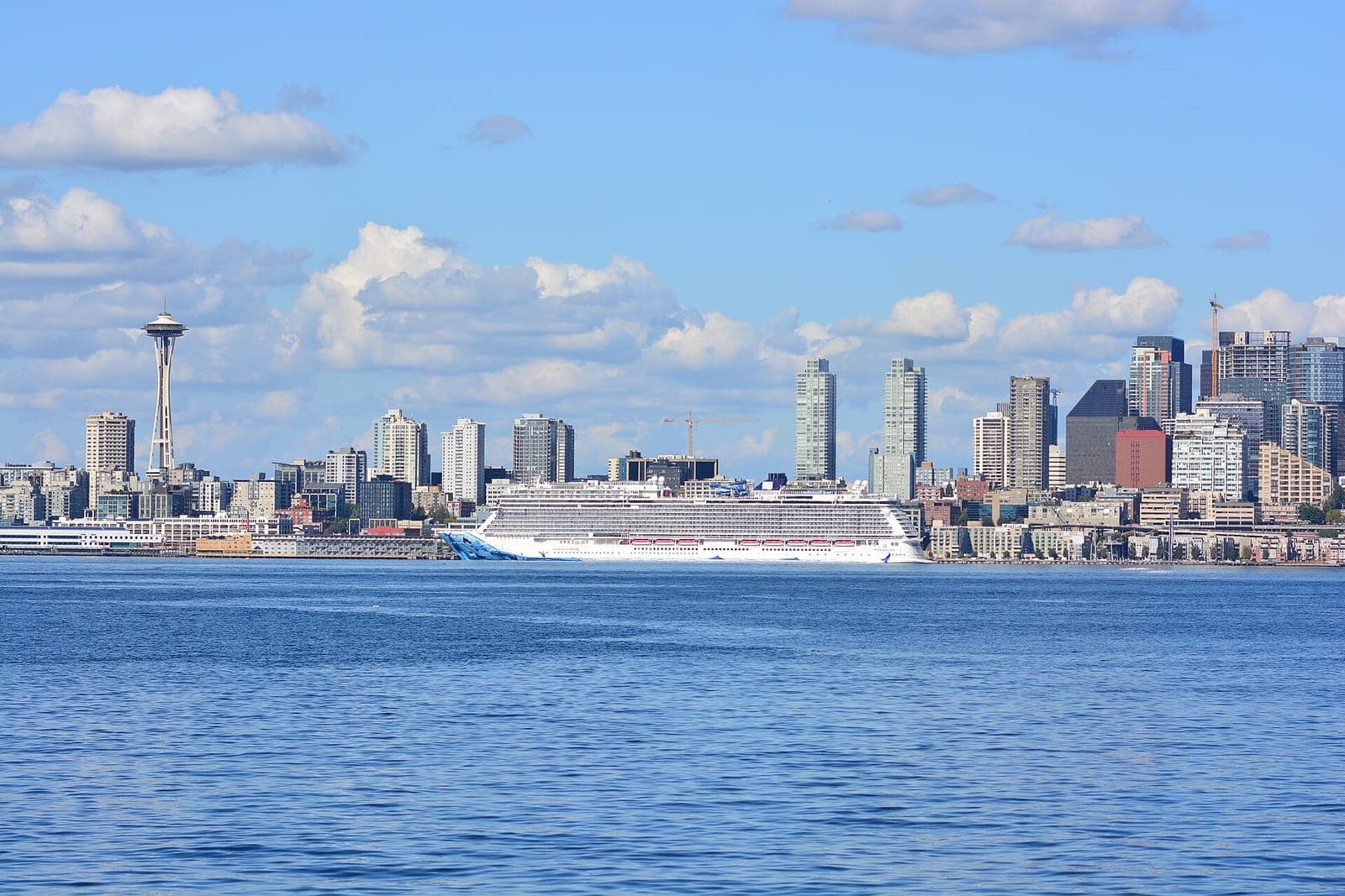 A cruise ship docked in front of the Seattle skyline and Space Needle