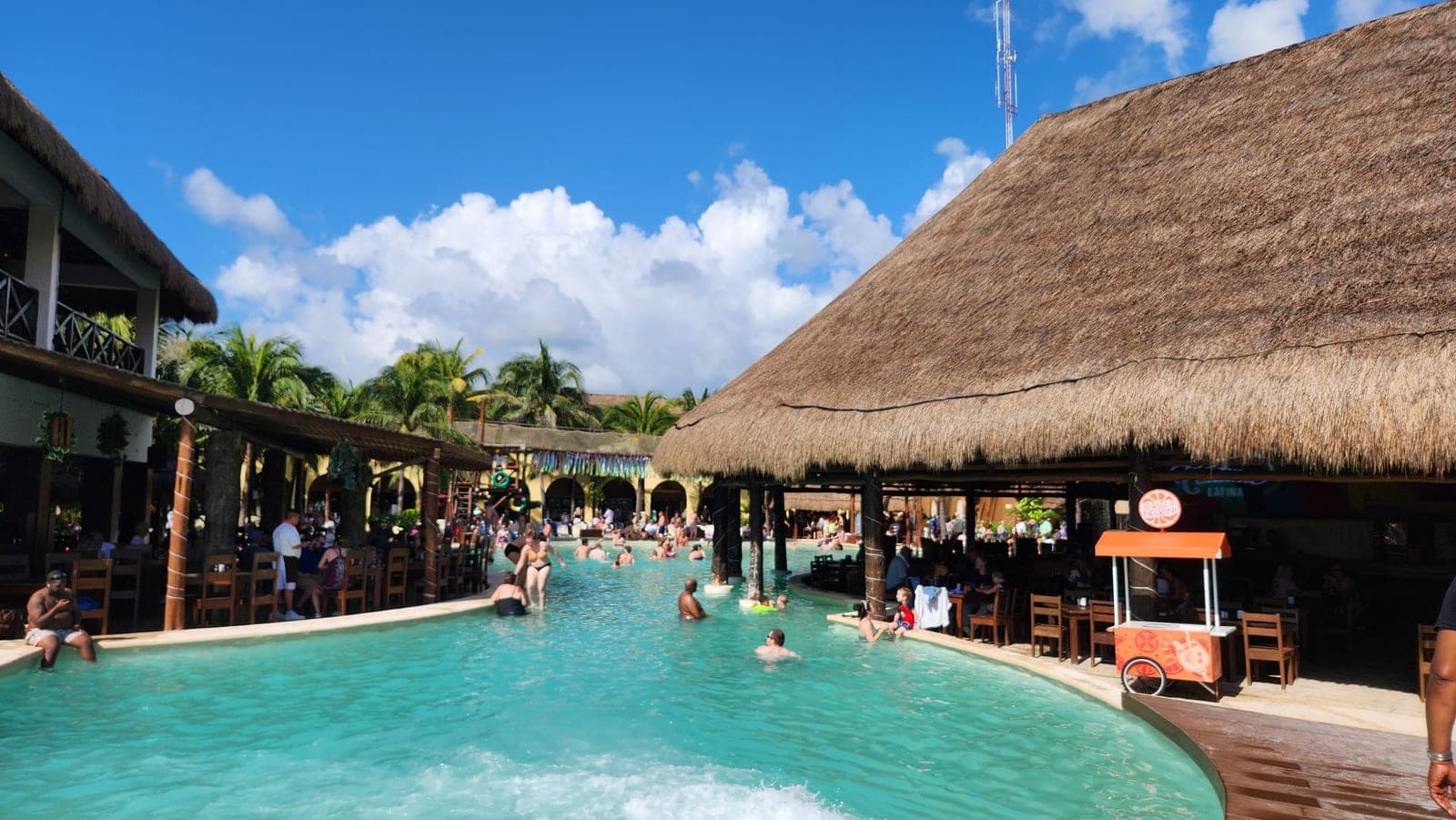 The Costa Maya cruise terminal's pool area with thatched palapa roofs and a drink cart