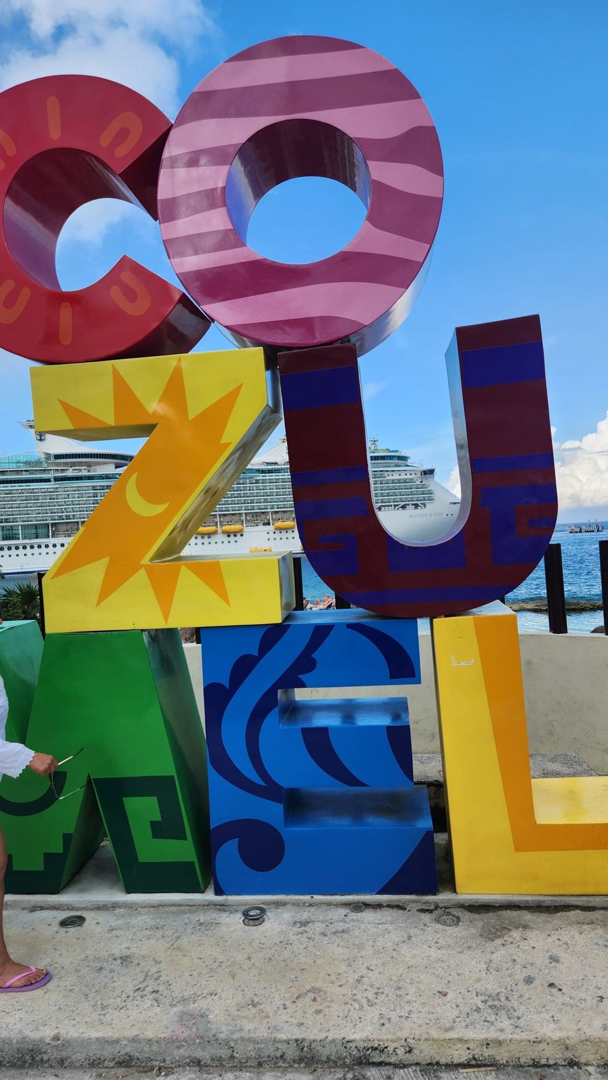 Colorful oversized COZUMEL letters on the waterfront with a Royal Caribbean ship docked behind