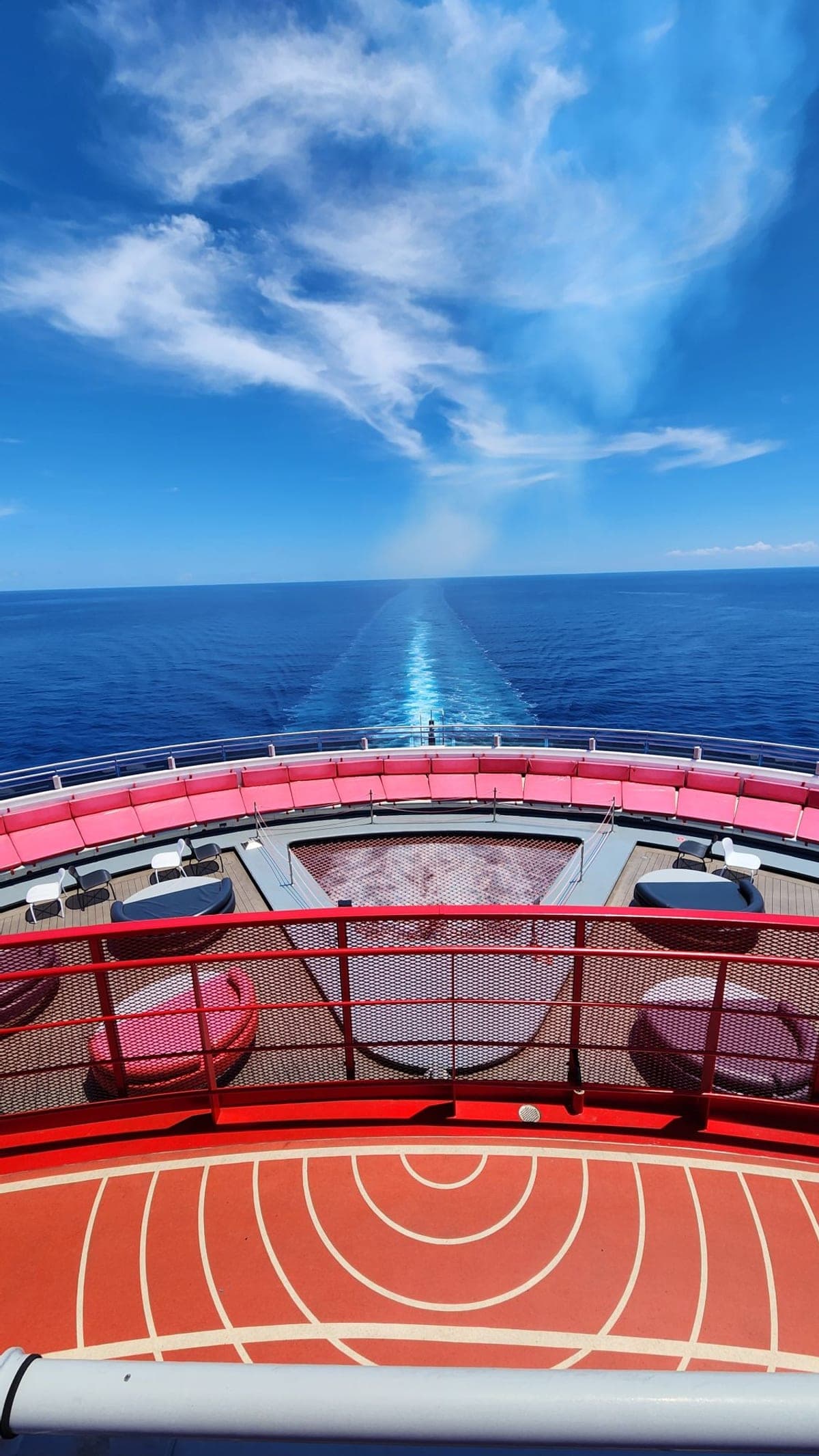 Looking back over Valiant Lady's red-railed aft deck at the ship's wake stretching across the ocean
