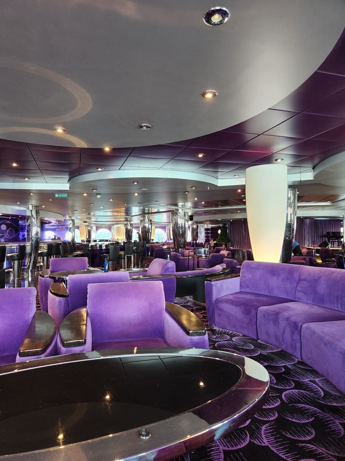 Purple velvet lounge seating and mirrored pillars in one of MSC Magnifica's onboard bars