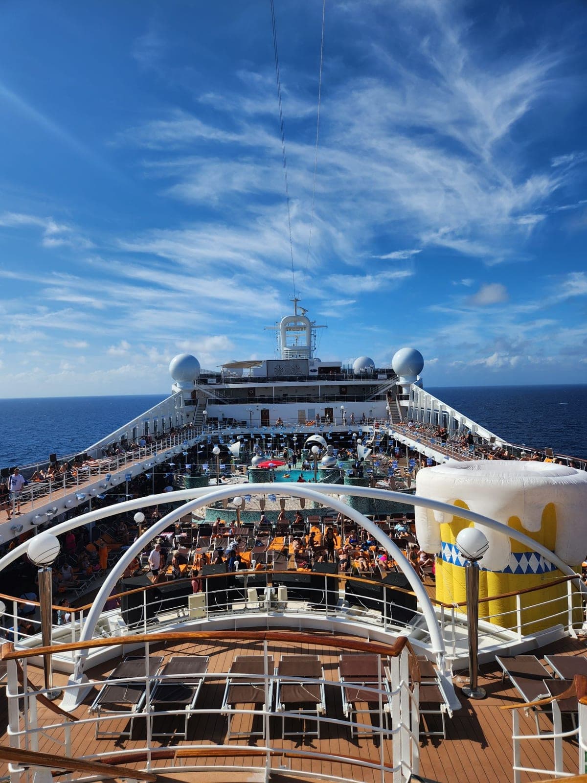 Forward pool deck aboard MSC Magnifica with sun loungers, a pool, and ocean views under a blue sky