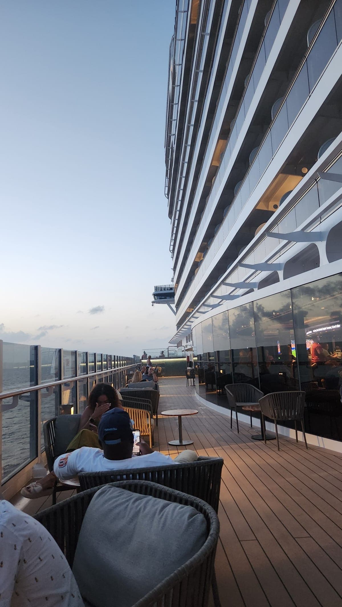An open-air deck lounge aboard MSC Seashore with wicker furniture at dusk