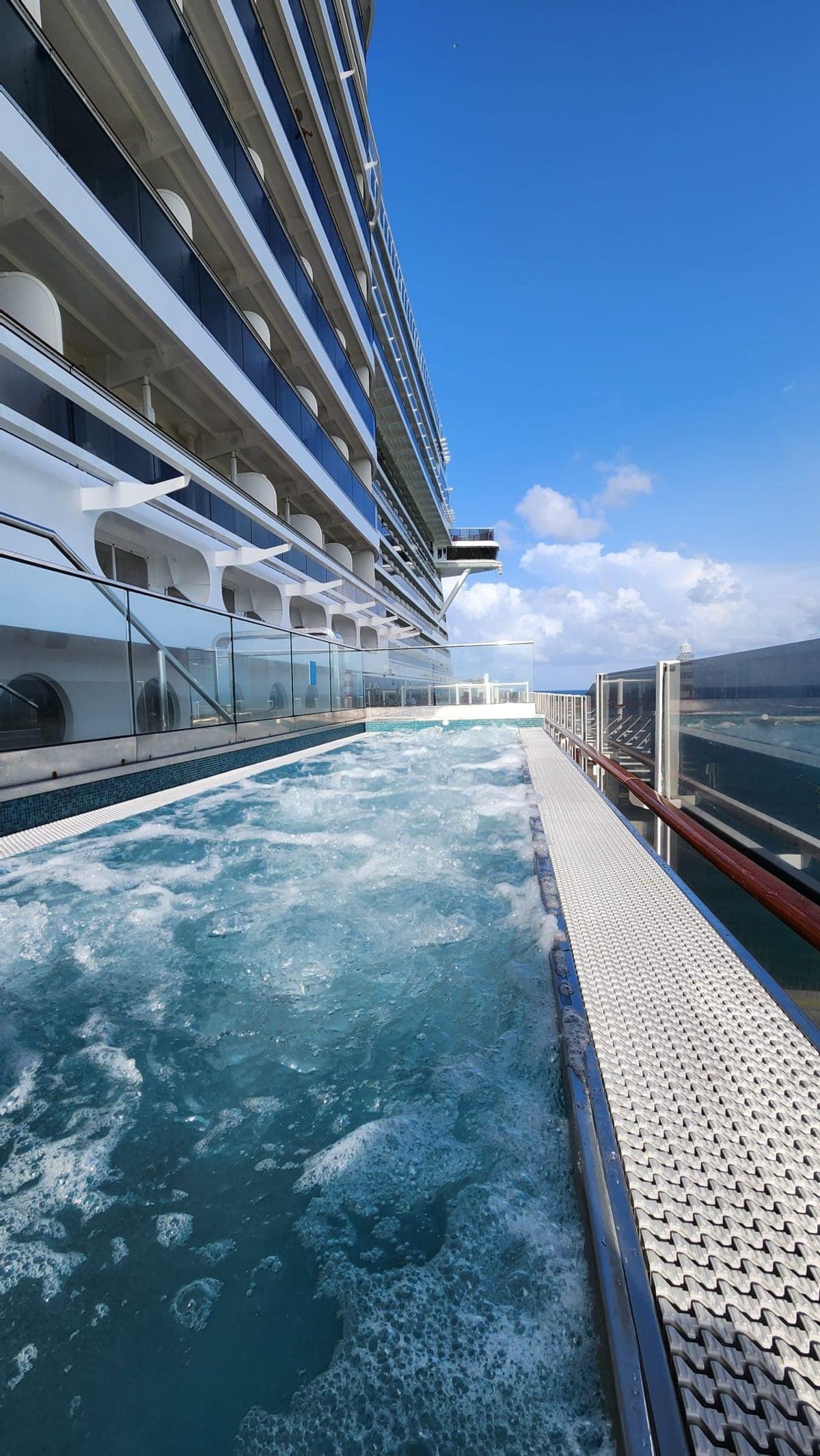 A bubbling whirlpool tucked against MSC Seashore's hull with balcony cabins rising above