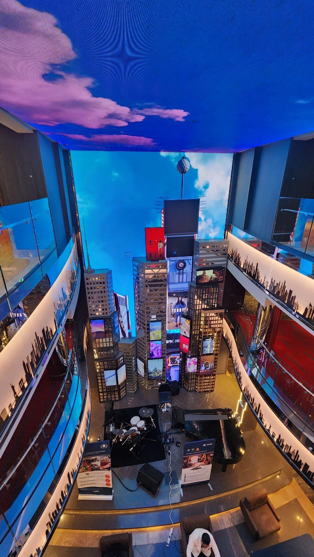 A themed lounge aboard MSC Seashore with a miniature city skyline of LED screens beneath a sky-effect ceiling