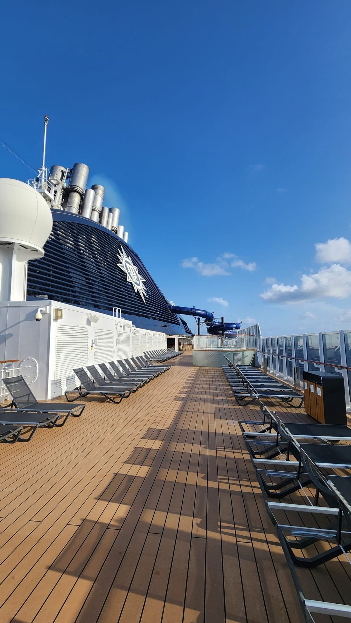 MSC Seashore's Top 19 pool deck with loungers, a waterslide, and the ship's funnel overhead