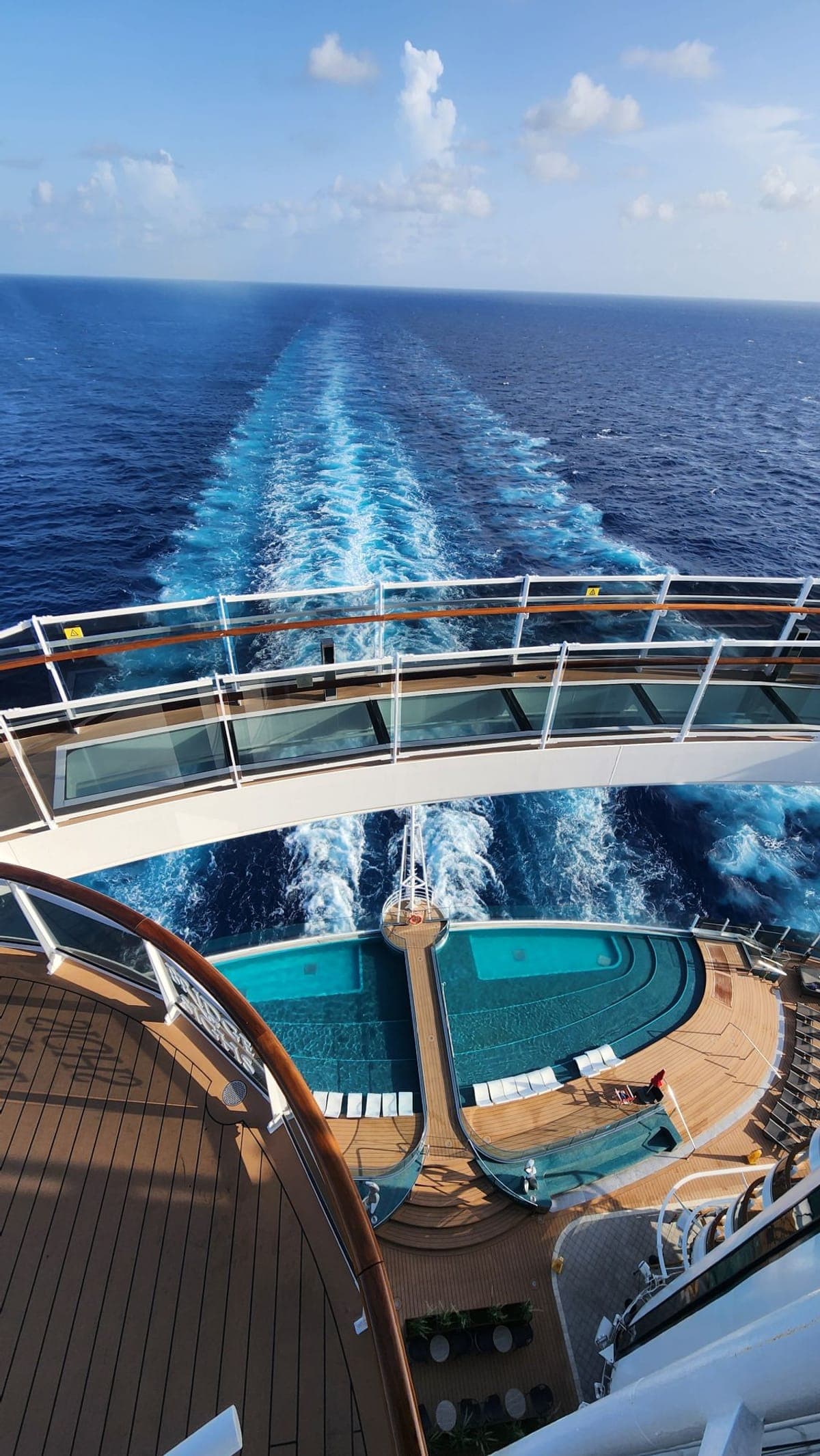 A multi-deck view down MSC Seashore's stern over pools and railings toward the ship's wake