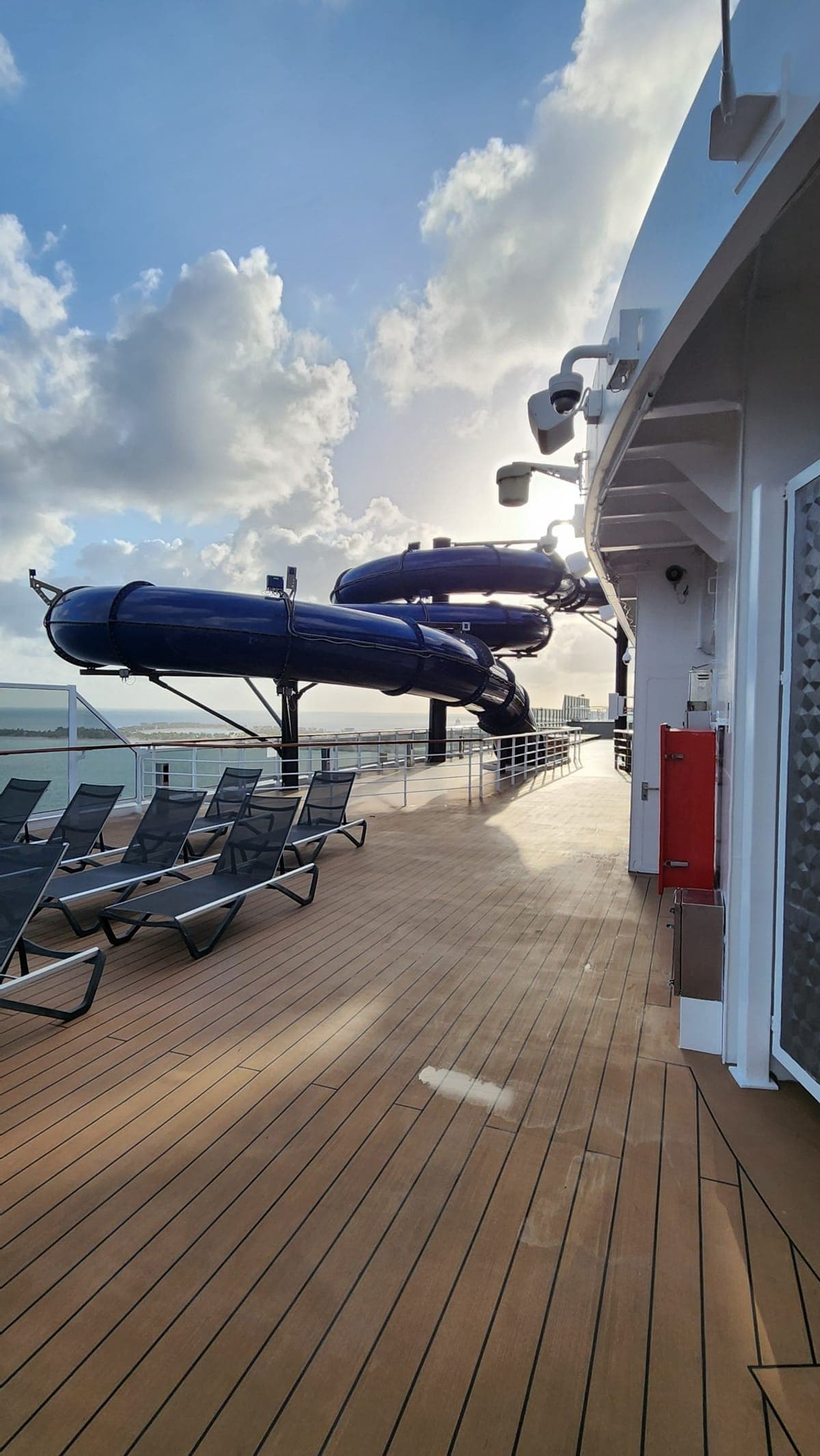 Blue waterslide tubes on MSC Seashore's upper deck against a clear sky and ocean view