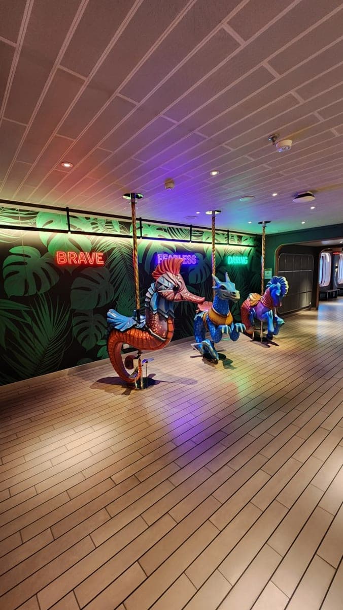 Colorful carousel horses beneath neon signs in the Resilient Lady corridor