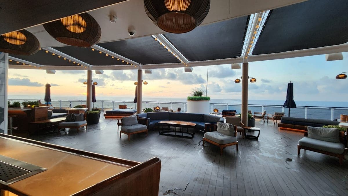 Resilient Lady oceanfront lounge with sofas, daybeds, and a sunset view over the sea