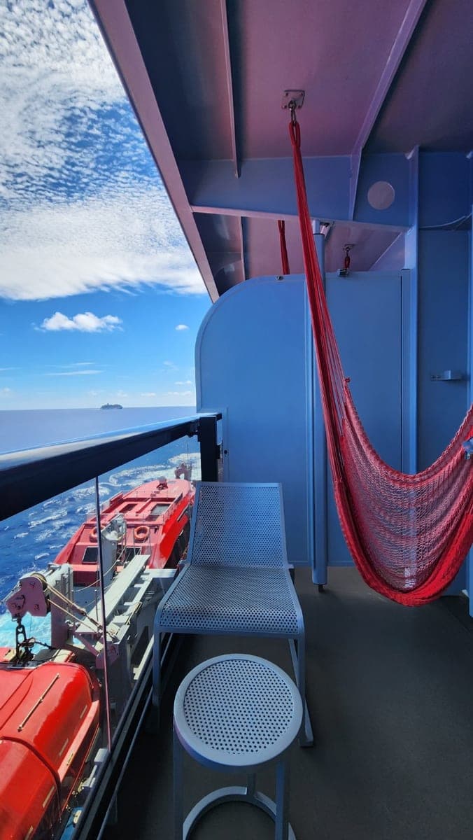 Resilient Lady Sea Terrace balcony with a red hammock, chair, and ocean view